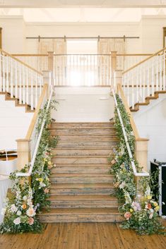 the stairs are decorated with flowers and greenery