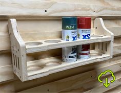 two cans of paint are sitting on a shelf next to some plywood planks