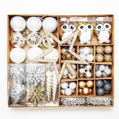 an open box filled with christmas ornaments and other items, including balls, candles, ornaments