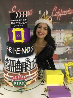 a woman standing next to a multi layer cake on top of a table with other items