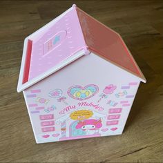 a pink and white toy house with hello kitty on it