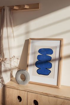 an art work is displayed on a wooden shelf