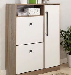 a white and brown cabinet with drawers next to a potted plant