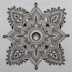 a black and white drawing of an intricate flower design on a piece of art paper