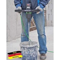 a man standing next to a cement bucket