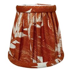 an orange and white lamp shade with leaves on it