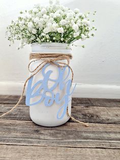 a mason jar filled with baby's breath flowers on top of a wooden table