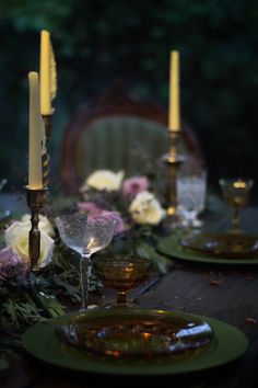 the table is set with candles and plates