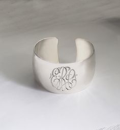 "This custom engraved cuff bangle will spell out your monogrammed initials in pretty script font. For different engraving, please inquire. Bangle will be amazing personalized gift for any occasions: graduation, birthday, Christmas, wedding, etc. Inside Diameter: 2.5\" (60mm adjustable) Bangle Width: 1.5\" mm (40mm) Metal Material: Sterling Silver ------ NOTE --------- Traditional monograms are made with the following order of initials taken from your name: FIRST, LAST, MIDDLE We assume that this Luxury Engraved Cuff Bracelet For Anniversary, Classic Engraved Cuff Bangle, Classic Engraved Cuff Bangle Bracelet, Elegant White Gold Name Bracelet With Engraving Option, Anniversary Engraved Cuff Bracelet, Engraved Cuff Bracelet For Anniversary, Elegant Sterling Silver Name Bracelet With Engraving Option, Elegant Silver Bangle With Engraving Option, Silver Customizable Cuff Bangle Bracelet