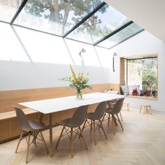 a dining room table and chairs in front of a skylight