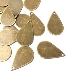 brass plated metal tears are scattered on a white surface