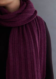 a woman wearing a purple scarf and black top