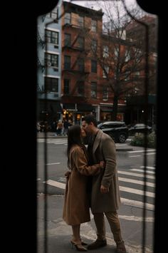 a man and woman kissing on the street