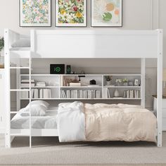 a white bunk bed sitting under two pictures on the wall