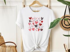 "Wrap your love in a vibrant embrace with our Heartful Harmony T-shirt! 🌈 Overflowing with joy, with the key features a kaleidoscope of brilliantly coloured hearts. Each colour signifies a unique moment, a cherished memory. Let your heart speak louder than words. Gift the magic of love. Wear the warmth, share the joy. Because every heartbeat deserves a celebration!  #HeartfulHarmony #LoveInEveryHue" ✨Sizing✨ Please note that the T-Shirt and its sizing is unisex. Please review the sizes in the l Valentine's Day Graphic Tee T-shirt Gift, Cute White T-shirt For Valentine's Day, Casual Valentine's Day Gift Tops, Casual Tops For Valentine's Day Gift, Valentine's Day Letter Print T-shirt Gift, Red T-shirt For Valentine's Day Gift, Mother's Day Short Sleeve T-shirt With Heart Print, White T-shirt With Heart Print For Mother's Day, White Heart Print T-shirt For Mother's Day