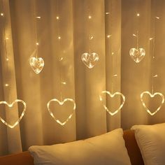 a bed with pillows and lights hanging from the headboard