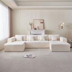 a large white couch sitting in a living room next to a window