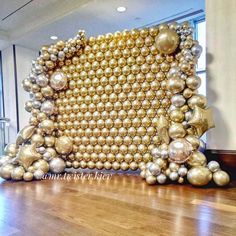 a large gold and silver sculpture sitting on top of a hard wood floor