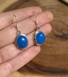 This listing is for one pair (2 earrings) of Blue Chalcedony Silver Lined Oval dangle 925 earrings. Chalcedony can be found translucent to opaque and in the colors of white, pink, blue, red or gray. Chalcedony is known to be a nurturing stone and helps to align the mind, body, and spirit. This stone is also known to dissipate negative energy and remove unwanted feelings of melancholia. Since Chalcedony is a good stone for balancing emotions, therefore, Chalcedony represents Balance & Removal of Blue Oval Cabochon Earrings For Gift, Blue Cabochon Sterling Silver Earrings, Blue Oval Cabochon Earrings As Gift, Sterling Silver Oval Cabochon Earrings Gift, Balancing Emotions, 925 Earrings, 2 Earrings, Silver Line, Throat Chakra