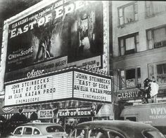 an old movie theater with cars parked on the street