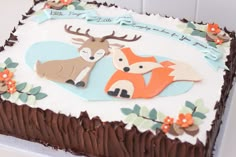 a birthday cake decorated with an image of two deer and a fox on the frosting