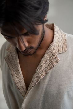 This Dawning Unisex Double Breasted Jacket comes in a calm and soothing color. This 30s cotton double breasted jacket is undyed and unbleached. It has a peak lapel, double pockets and a three-closure button front. The loops and pocket flap are adorned with the stitches of Kantha, a form of Indian hand embroidery. *This item is a final sale and not eligible for returns or exchanges. *This item can take up to 14 business days to ship as it is made to order for you. Indian Man Style, Indian Shirts For Men, Indian Hand Embroidery, Indian Menswear, Slow Clothing, Menswear Details, White Pant, Pocket Embroidery, Wrap Top Blouse