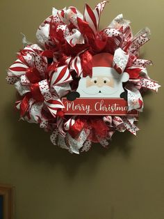 a christmas wreath hanging on the wall with a santa clause face and candy canes