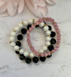 "Gorgeous bracelet stack made of 10mm faceted round black beads, 8mm white marble glass beads and 6mm pink glass cat's eye round beads, as well as gold spacer beads. The bracelets shown are approximately 7\" in length." Pink Beaded Bracelet, Anting Manik, Pink Beaded Bracelets, White Beads Bracelet, Diy Bracelets Tutorials, Eye Round, Bracelet Sets, Bracelets Design, Beads Bracelet Design