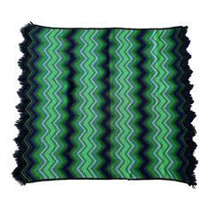 a green and black rug with fringes on it's edges, in the shape of zigzag