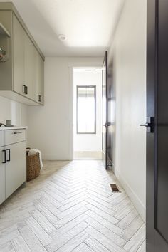 an empty kitchen with herringbone tile flooring