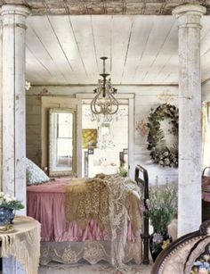 a bedroom with a bed and chandelier hanging from it's ceiling in an old house