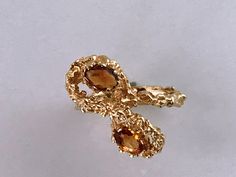 Rare Vintage 14kt Gold Brutalist Ring With Two Citrine Stones. Unique brutalist twist figure eight dome with two oval seated orange stones. Make a statement with this unique chunky piece of jewelry. Markings: SECO 14k Measurements: Ring Size 6, Stones- 5.4mm each Total Weight: 5.26 grams Condition: Great Vintage condition, ready to wear. Please review the photos for visual detail and let me know if you have any further questions prior to purchase. I don't offer returns or exchanges. USA sales on Unique Yellow Gold Topaz Ring For Formal Occasions, Unique Oval Yellow Gold Topaz Ring, Unique Citrine Ring In Yellow Gold, Unique Gold Topaz Ring For Formal Occasions, Gold Topaz Ring With 17 Jewels In 14k Gold, Unique Gold Topaz Ring, 14k Gold Topaz Ring With 17 Jewels, Gold Topaz Ring Stamped 14k, Jewelry Markings