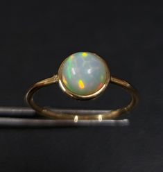 1. ethiopian opal 14k gold ring 2. made to order  3. gemstone - ethiopian opal 4. jewelry type - gold ring 5. total weight - 1.300 gram approx 6. opal weight - 1.03 cartas 7. gold weight - 1.093 gram approx 8. opal size - 7 mm 9. gold purity - 14k 10. handmade items 11. band size - 1.50 mm 12. high polished 13. aaa quality ring  14. stackable ring 15. 1 quantity available 16. ready to dispatch in 1 -2 days. 17. rare size / rare fire Yellow Gold Moonstone Ring With Ethiopian Opal, Fine Jewelry Yellow Gold Moonstone Ring With Ethiopian Opal, Yellow Gold Moonstone Ring With Ethiopian Opal For Gift, Ethiopian Opal Moonstone Ring In Yellow Gold For Gift, Gold Ethiopian Opal Cabochon Ring, Ethiopian Opal Moonstone Ring Fine Jewelry, Yellow Gold Ring With Ethiopian Opal And Birthstone, Yellow Gold Ethiopian Opal Ring For Anniversary, Yellow Gold Ethiopian Opal Anniversary Ring