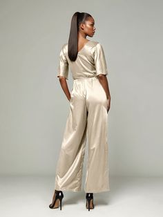 This soft satin jumpsuit features a flattering v-neck design, making it the perfect choice for mothers of the bride. Its dress pantsuit style provides comfort and elegance, while its high-quality material ensures a polished look. Stay stylish and comfortable on that special day with our jumpsuit. Chic Satin V-neck Jumpsuits And Rompers, Satin V-neck Jumpsuits And Rompers For Party, Elegant Satin Jumpsuit Or Romper In Solid Color, Satin Jumpsuit With V-neck For Party, Satin V-neck Jumpsuit For Party, Party Satin V-neck Jumpsuits And Rompers, Formal Satin V-neck Jumpsuit, Elegant Satin Pantsuit For Evening, Elegant Wide Leg Sets