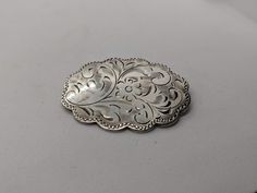 Superb vintage Burkhardt sterling silver floral engraved brooch measuring 1.5 inches long. Oval floral engraved medallion brooch with scalloped edges. There is a slight amount of tarnish on the back, the buyer can easily polish this off. It is otherwise, in great vintage condition. The back may look like it is dented, but it is not, it's most likely a reflection. I'll ensure your order is fulfilled as requested. Visit my shop at: newagainclassics.ca Vintage Turquoise Ring, Garnet Ring Silver, Sterling Silver Garnet Ring, Precious Stones Rings, Garnet Jewelry, Dec 7, Scalloped Edges, Vintage Turquoise, Diamond Pendant Necklace