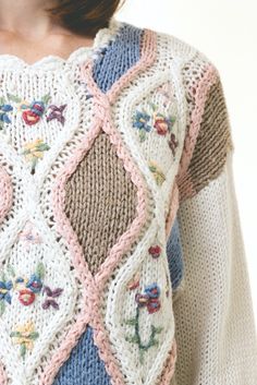 a close up of a woman wearing a sweater with flowers on the front and sides