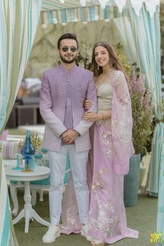 a man and woman standing in front of a gazebo