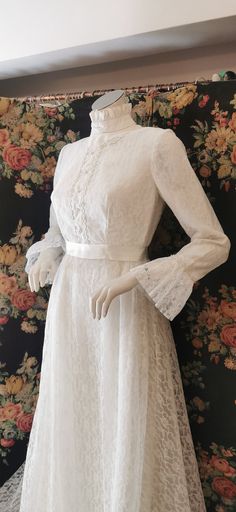 a white dress on display in front of a floral wall