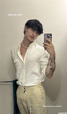 a man taking a selfie in front of a mirror with tattoos on his arm