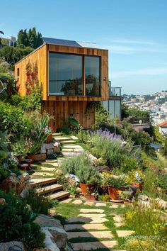 a house on top of a hill with lots of plants