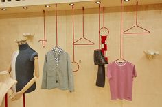 clothes are hanging on hooks in a display