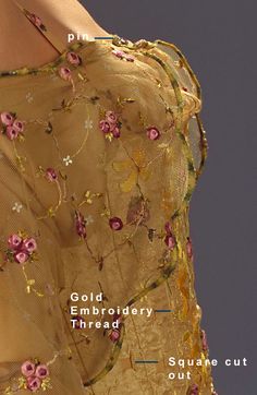 the back of a woman's dress with pink flowers and gold embroidery on it