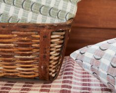 a basket sitting on top of a bed next to a pillow and throw pillow cover