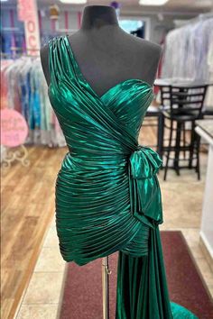 Shine bright at your homecoming in the Metallic Green One-Shoulder Ruched Dress. This eye-catching dress is made from luxurious polyester fabric and is available in striking green, royal blue, and rose gold colors. The one-shoulder design adds a modern touch, while the pleated embellishments create a flattering look making this dress a must-have for any special occasion. Details: Silhouette: Sheath Style Fabric: Polyester Fabric Color: Green, Royal Blue, Rose Gold Color Length: Short Mini Length Green Draped Evening Dress For Party, Green Ruched Evening Dress For Party, Fitted Green One Shoulder Prom Dress, Green Fitted One Shoulder Prom Dress, Fitted Green One-shoulder Prom Dress, Green Draped Prom Dress, Green Draped One Shoulder Party Dress, One-shoulder Green Evening Dress For Night Out, Green One-shoulder Evening Dress For Night Out