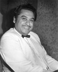 a black and white photo of a man in a bow tie smiling at the camera