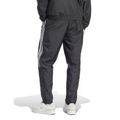 Influenced by the track but made for the streets, the adidas Tiro Woven Men's Pants have a classic style and a relaxed fit. You'll move, stretch, and bend, never feeling an ounce of restraint. Whether you want to keep your hands warm or a few of your essentials handy, you'll have pockets to do just that. Features adidas tri-stripe design. Elastic waistband. Two front pockets. Has logo on left thigh. Adidas Relaxed Fit Jogging Pants, Adidas Logo Pants With Relaxed Fit For Jogging, Adidas Gym Pants With Three Stripes, Adidas Logo Sweatpants For Training, Adidas Relaxed Fit Joggers For Streetwear, Adidas Relaxed Fit Sports Pants, Adidas Jogging Pants With Three Stripes, Athleisure Adidas Logo Joggers For Streetwear, Three Stripes Branding Relaxed Fit Joggers For Streetwear