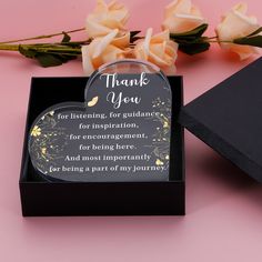 a thank you card in a black box next to flowers