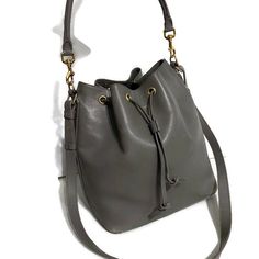 Saint Laurent Bucket Bag In A Gray Leather With Gold Hardware, Side Zippered Pocket, 5 Gold Feet, Detachable Tube Top Handle To Wear On The Shoulder With 9”Drop, Also Detachable Crossbody Strap With Drop Of 21”, Suede Lining With A Slid In Pocket With Name Tag On It And Serial Number. Bag Has Some Scratches From Wearing But Still In Great Condition. Gray Leather, Name Tag, Grey Leather, Crossbody Strap, Tube Top, Gold Hardware, Top Handle, Bucket Bag, Saint Laurent