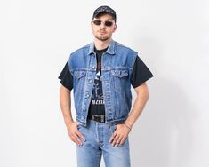 "Vintage 90s sleeveless denim jacket in stonewashed blue - brand: Bugjo - made of heavyweight denim - 4 outer pockets - materials: denim SIZE: size from label: no label best fits men: M/L (can be worn as an oversized piece by a person in a smaller size) MEASUREMENTS: chest: 45 inches (114 cm) length: 25 inches (64 cm) The model is 6'1\" (186 cm), measures 41-35-39 (104-88-100 cm) CONDITION: The vest in great vintage condition. Washed, ready to wear." Sleeveless Denim Vest For Spring Streetwear, Sleeveless Outerwear For Summer Streetwear, Sleeveless Summer Outerwear For Streetwear, Summer Sleeveless Outerwear For Streetwear, Sleeveless Denim Vest With Pockets For Streetwear, Sleeveless Denim Jacket For Spring Streetwear, Casual Sleeveless Denim Jacket For Streetwear, Summer Streetwear Vest With Pockets, Light Wash Cotton Denim Vest For Streetwear