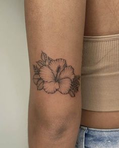 a woman's arm with a flower tattoo on the left side of her arm